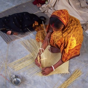 Woman weaving a mat for Sasha